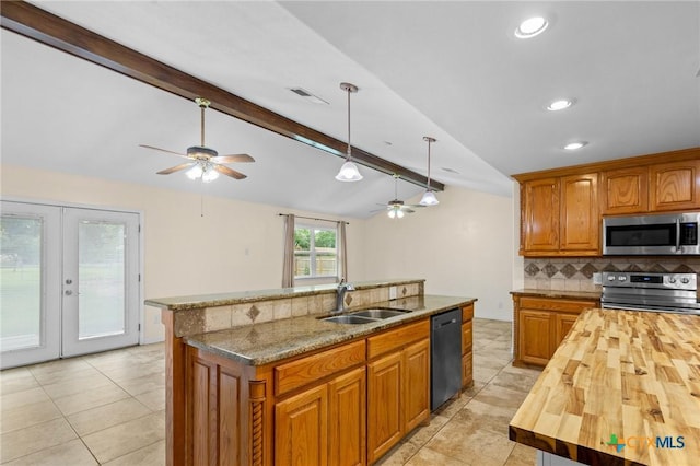 305 Berwick St, Victoria, TX 77904 - kitchen with appliances with stainless steel finishes, wood counters, a ceiling fan, backsplash, and an island with sink