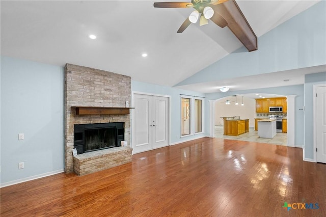 305 Berwick St, Victoria, TX 77904 - unfurnished living room featuring a ceiling fan, a fireplace, light wood-style floors, arched walkways, and recessed lighting