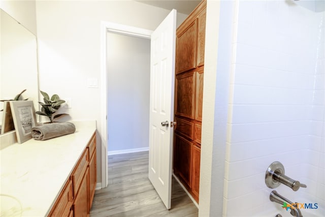 bathroom featuring vanity, hardwood / wood-style floors, and shower / bathtub combination