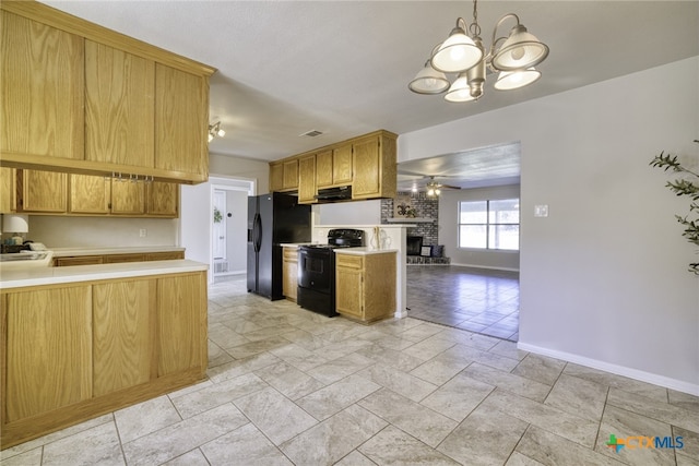 kitchen with ceiling fan with notable chandelier, a fireplace, black appliances, decorative light fixtures, and kitchen peninsula