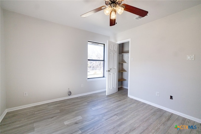 unfurnished bedroom with light wood-type flooring, ceiling fan, and a closet