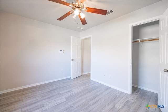 unfurnished bedroom featuring ceiling fan, light hardwood / wood-style floors, and a closet