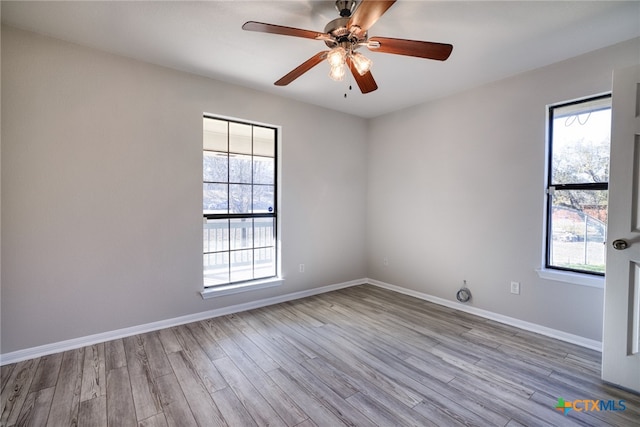 unfurnished room with ceiling fan, a wealth of natural light, and light wood-type flooring