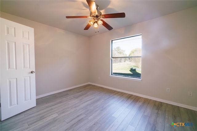 spare room with ceiling fan and light wood-type flooring