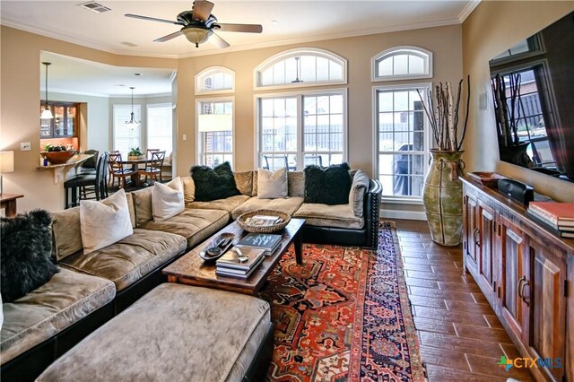 207 C L Duckett Dr, Cuero, TX 77954 - living room with decorative columns, ceiling fan, crown molding, baseboards, and wood finished floors