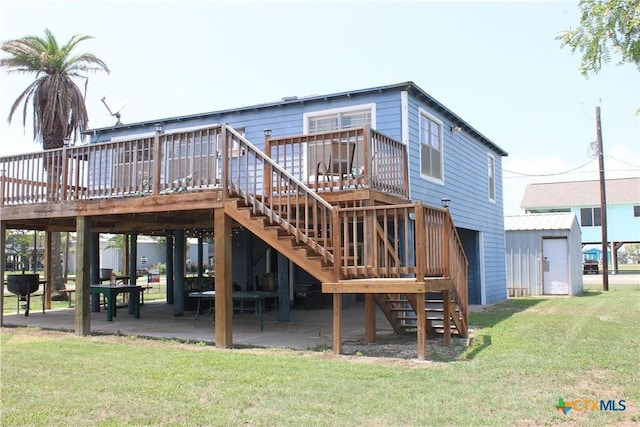 rear view of property with a deck, a patio area, and a lawn