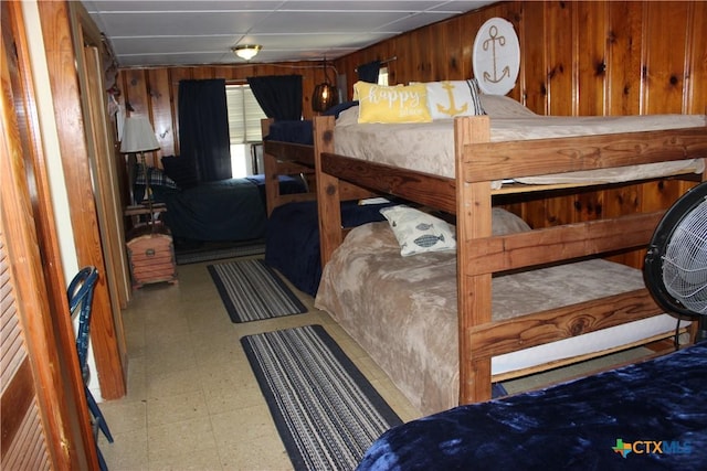 bedroom featuring wooden walls