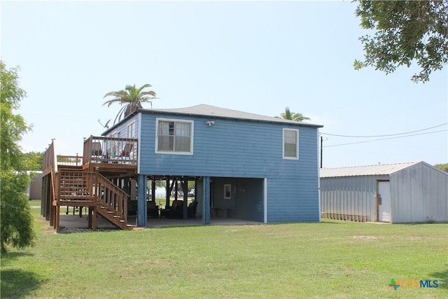 back of house with a lawn, an outdoor structure, and a deck