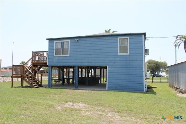 rear view of property featuring a lawn and a deck