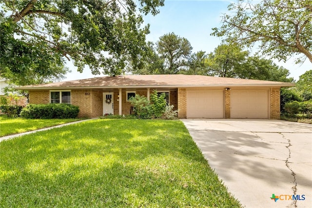 812 Merritt Dr, Lockhart, TX 78644 - ranch-style house with a garage, a front yard, brick siding, and driveway