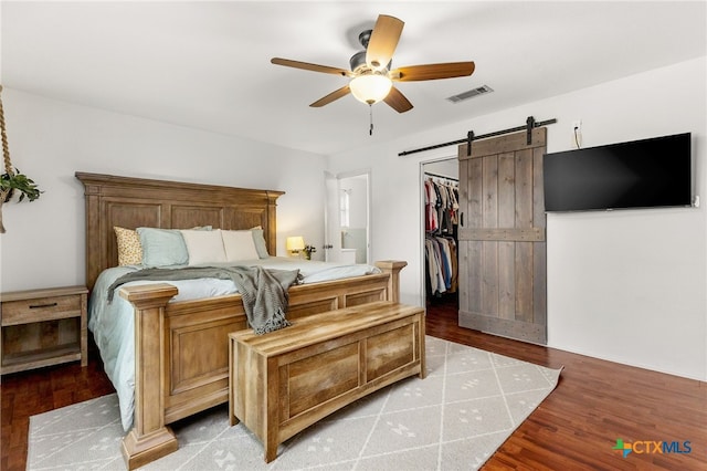 812 Merritt Dr, Lockhart, TX 78644 - bedroom featuring a barn door, a spacious closet, light wood-type flooring, and a ceiling fan