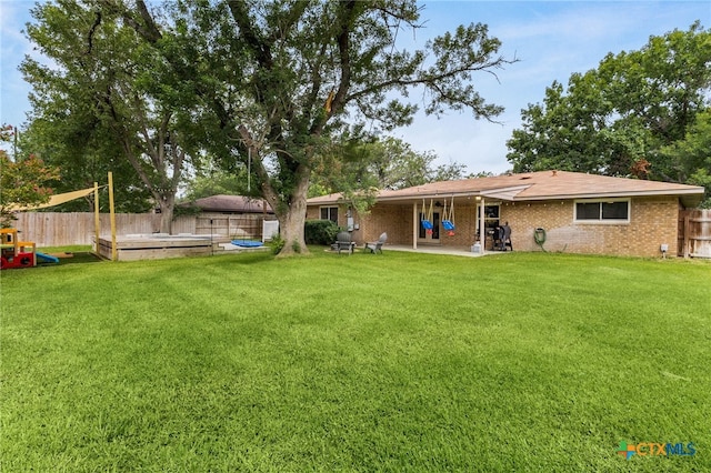 812 Merritt Dr, Lockhart, TX 78644 - back of property with a fenced backyard, a patio, and brick siding