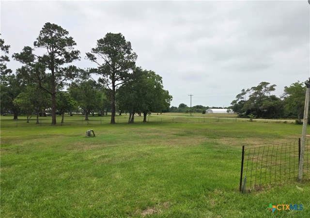 surrounding community featuring a yard and a rural view