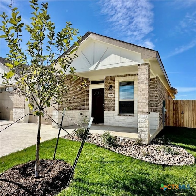 view of front of property featuring a porch, a front lawn, and a garage