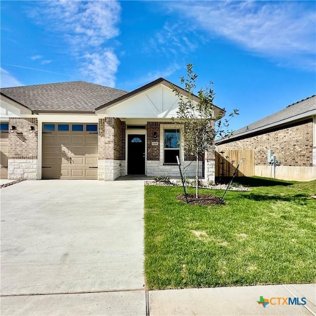 view of front of property featuring a front yard and a garage