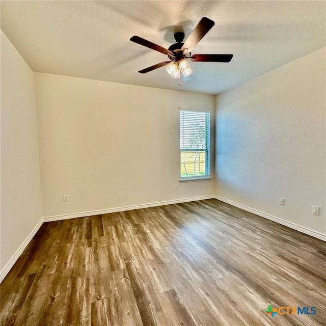 unfurnished room with dark wood-type flooring and ceiling fan