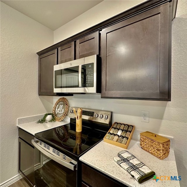 kitchen with dark brown cabinetry and appliances with stainless steel finishes