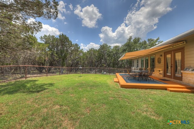 view of yard featuring a wooden deck and french doors