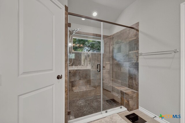 bathroom with a shower with door