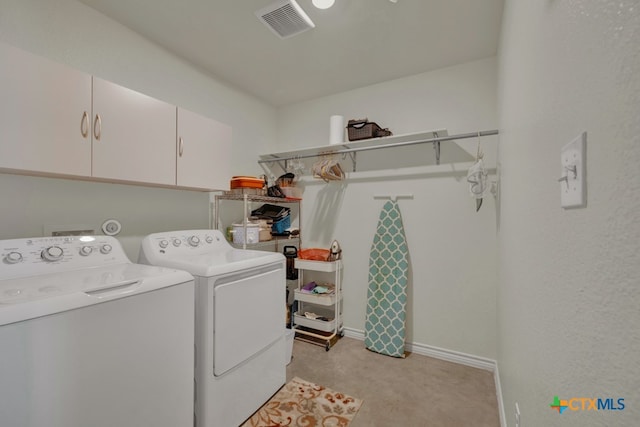 washroom featuring cabinets and separate washer and dryer