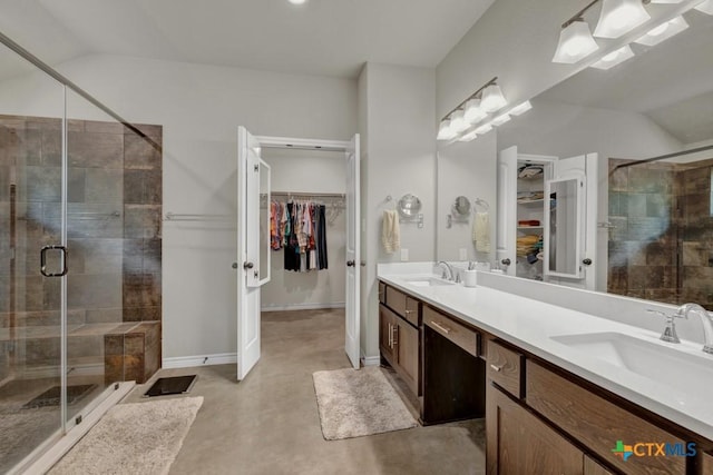 bathroom with lofted ceiling, vanity, concrete flooring, and a shower with shower door