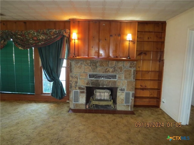 unfurnished living room with carpet flooring and a stone fireplace