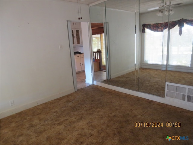 empty room with carpet and ceiling fan