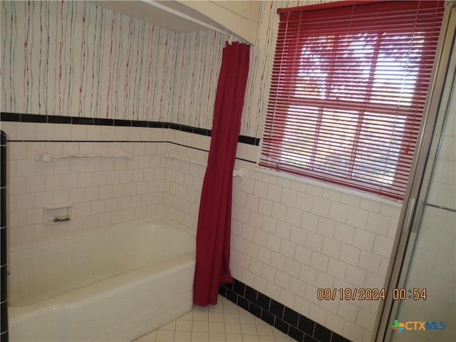 1124 Refugio Hwy, Victoria, TX 77905 - full bathroom with tile walls, tile patterned floors, a tub to relax in, wainscoting, and a shower