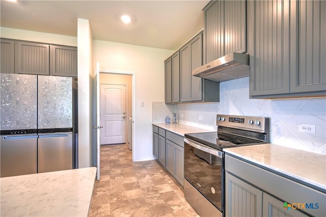 kitchen with under cabinet range hood, gray cabinetry, appliances with stainless steel finishes, and backsplash