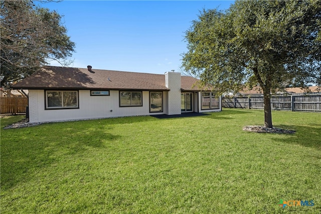 back of house featuring a lawn