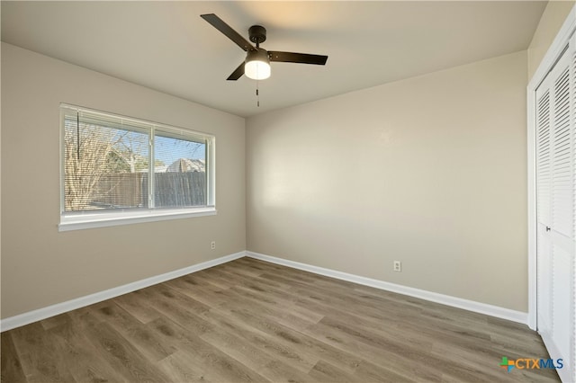 unfurnished bedroom with wood-type flooring, a closet, and ceiling fan