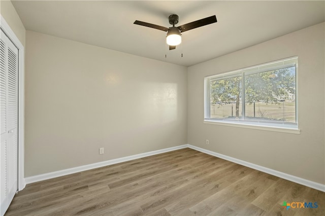 unfurnished bedroom featuring ceiling fan, hardwood / wood-style floors, and a closet