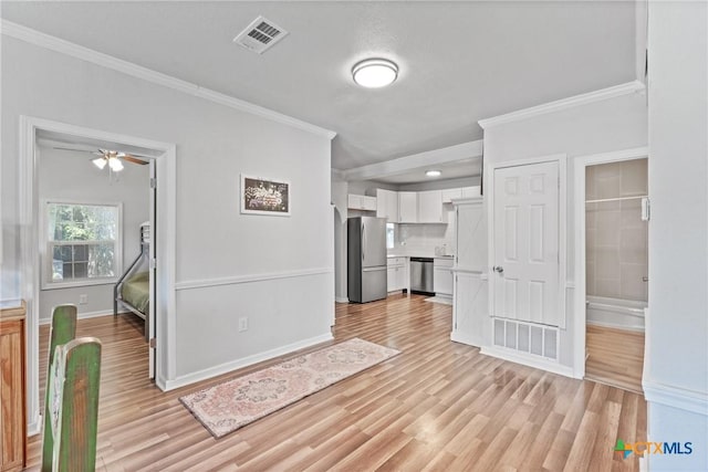 1107 Waco St, Gatesville, TX 76528 - unfurnished living room featuring crown molding, light wood-type flooring, baseboards, and a ceiling fan