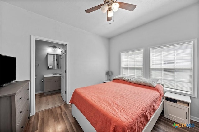 1107 Waco St, Gatesville, TX 76528 - bedroom featuring wood finished floors, baseboards, a sink, and ensuite bath