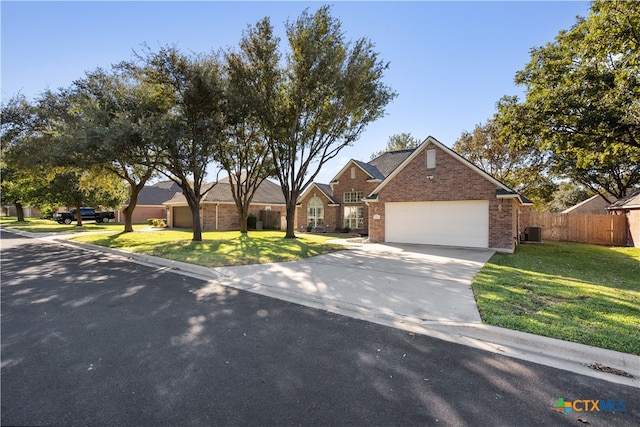 view of front of property with a front lawn, central AC unit, and a garage