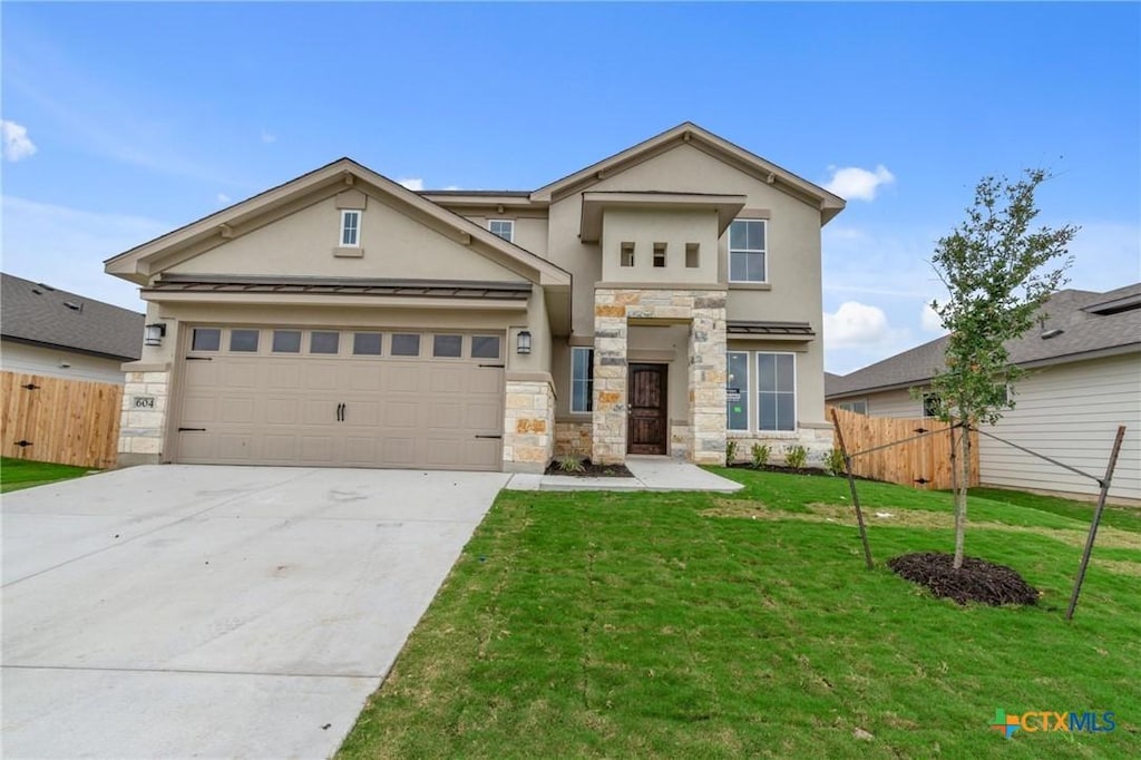 view of front of home with a front yard and a garage