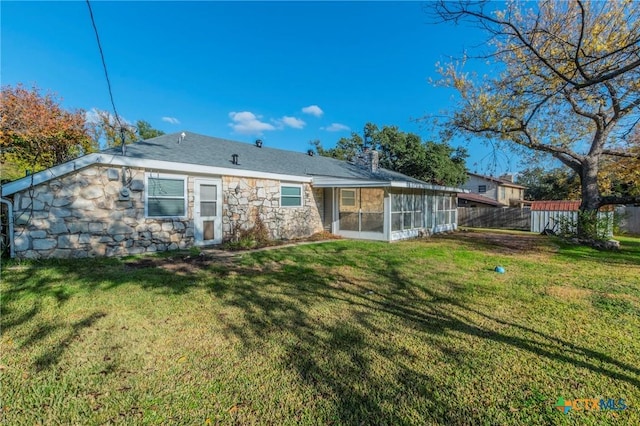 back of house featuring a sunroom and a yard