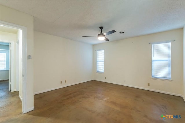 empty room featuring a wealth of natural light and a textured ceiling