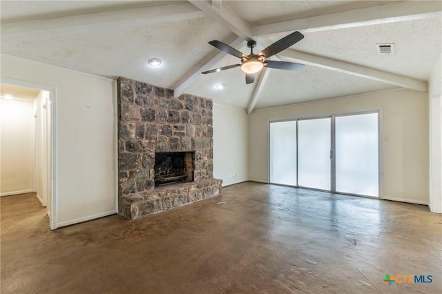 unfurnished living room with ceiling fan, a stone fireplace, lofted ceiling with beams, concrete flooring, and a textured ceiling