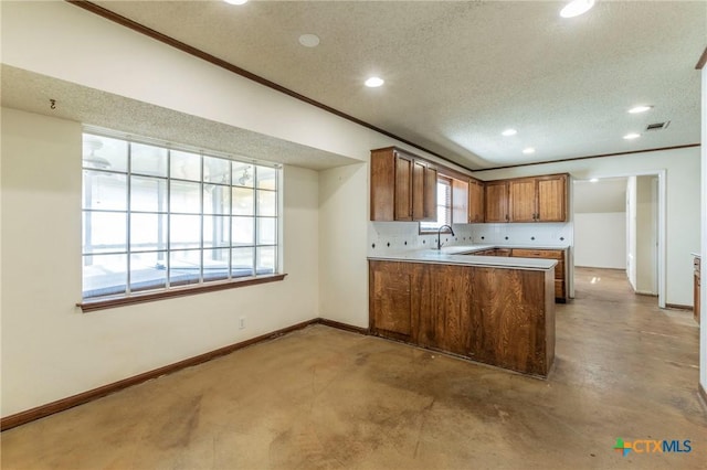 kitchen featuring kitchen peninsula, a textured ceiling, and a healthy amount of sunlight