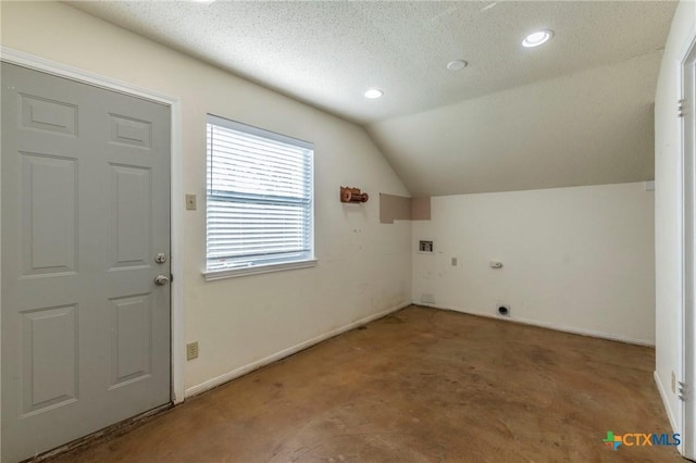 interior space featuring carpet floors, a textured ceiling, and vaulted ceiling