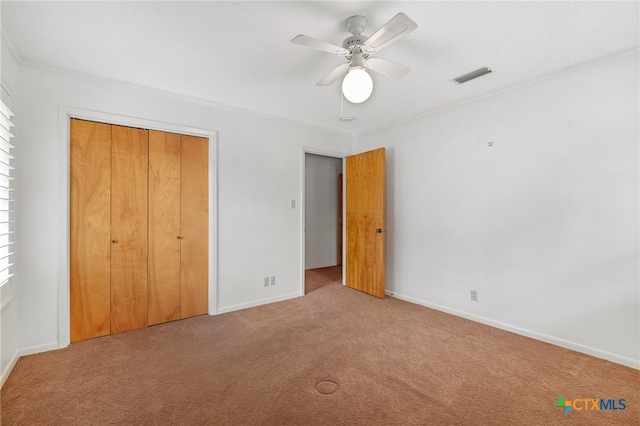 unfurnished bedroom with ceiling fan, a closet, and carpet floors