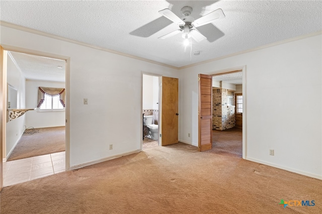 unfurnished bedroom featuring a textured ceiling, light carpet, ceiling fan, and ensuite bathroom