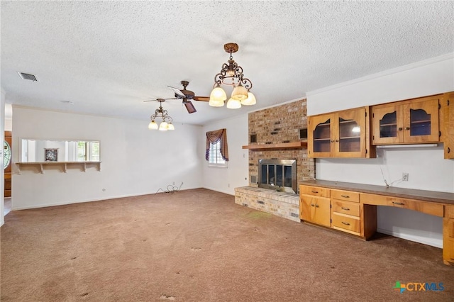 125 Hillview Dr, Luling, TX 78648 - unfurnished living room with a chandelier, healthy amount of natural light, a brick fireplace, carpet flooring, and a textured ceiling