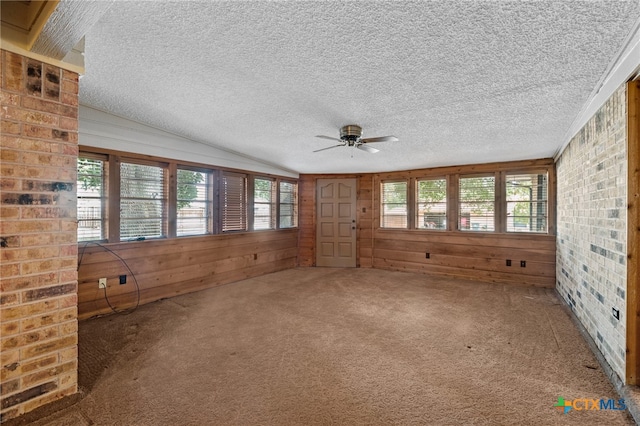 unfurnished sunroom with ceiling fan, plenty of natural light, and vaulted ceiling