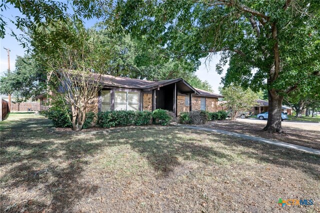 ranch-style home featuring a front lawn