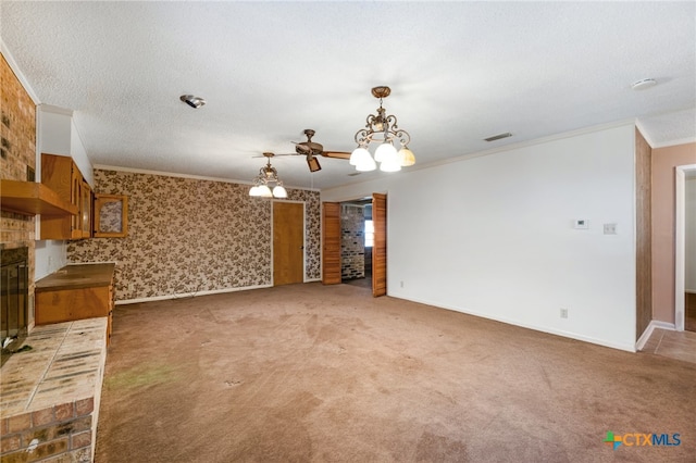 unfurnished living room featuring ceiling fan with notable chandelier, a textured ceiling, crown molding, and carpet