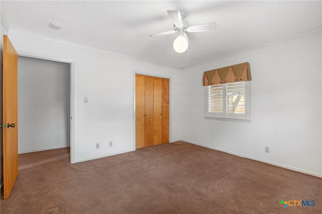 unfurnished bedroom featuring a closet, ornamental molding, carpet floors, a textured ceiling, and ceiling fan