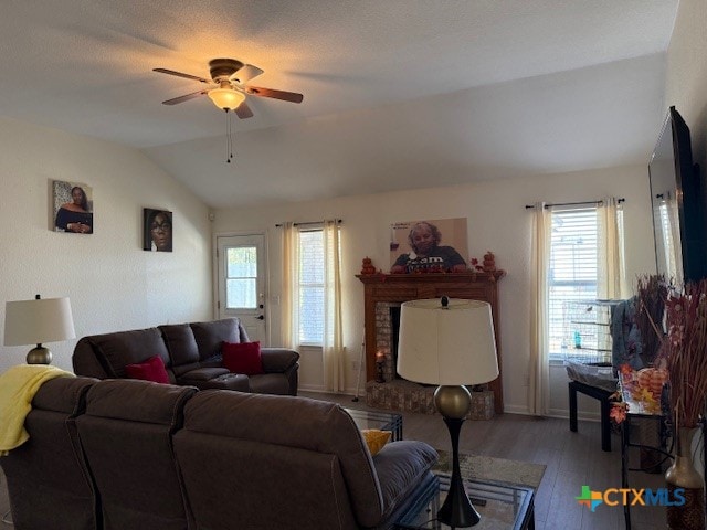 living room featuring plenty of natural light, lofted ceiling, ceiling fan, and light hardwood / wood-style flooring