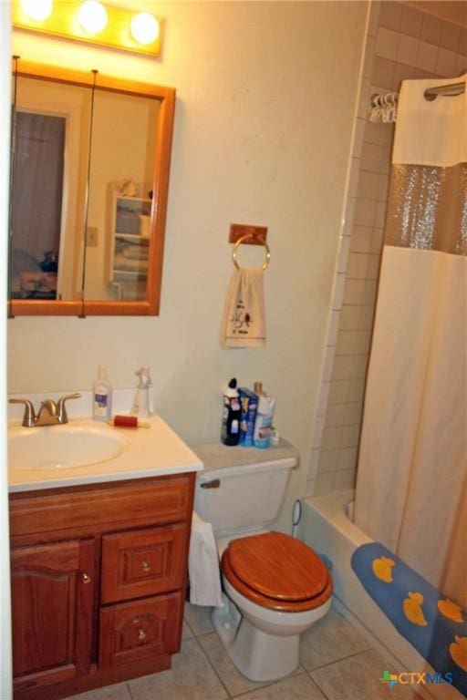 full bathroom featuring vanity, shower / bath combo with shower curtain, tile patterned floors, and toilet